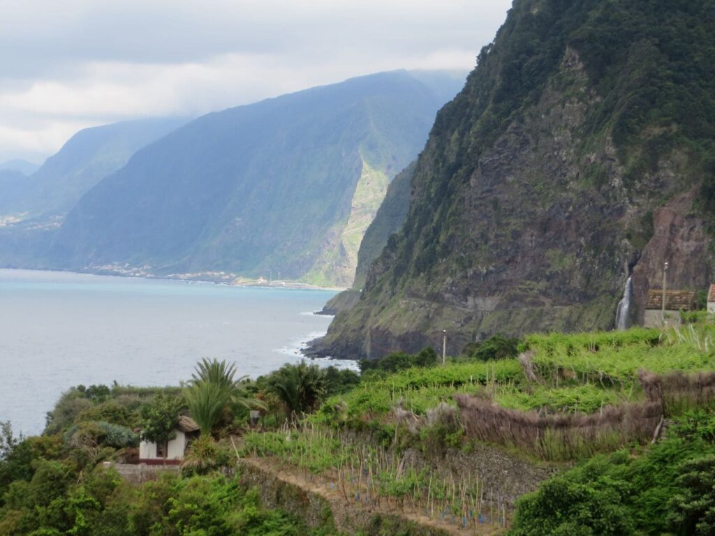 Terrazzamenti coltivati e cascata che si getta nell'oceano a Seixal, Madeira
