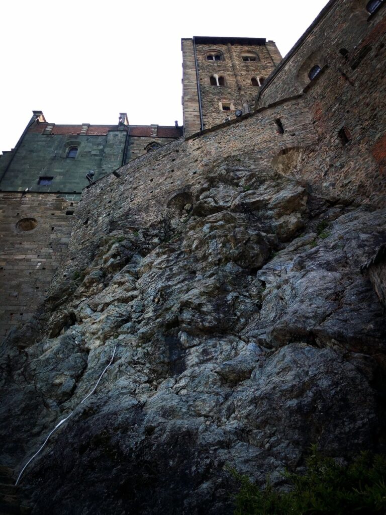 Sacra di San Michele, abbaye romane surplombant la roche des Alpes piémontaises, fusion parfaite entre architecture et nature.