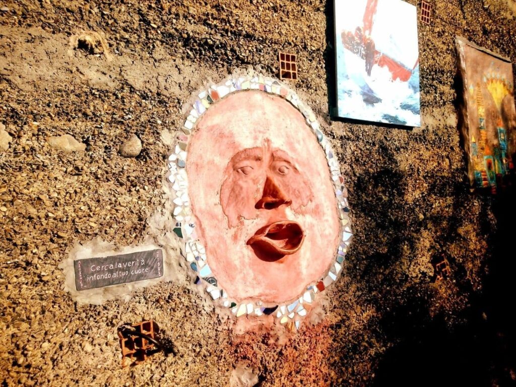Scultura della Bocca della Verità all'ingresso di Bussana Vecchia.